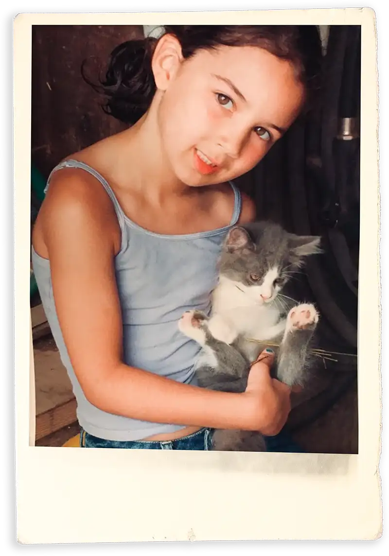 Siena Bott as a child holding a kitten in a Polaroid picture frame
